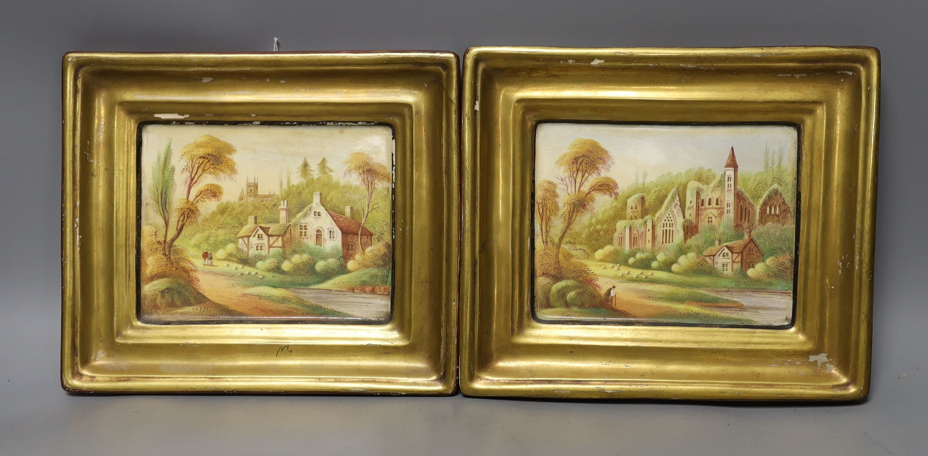 A pair of 19th century painted pottery hanging wall plaques depicting village scenes - 17 x 20cm